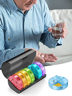 a person holding a glass of water and a pill box with text: 'SUN TUE'