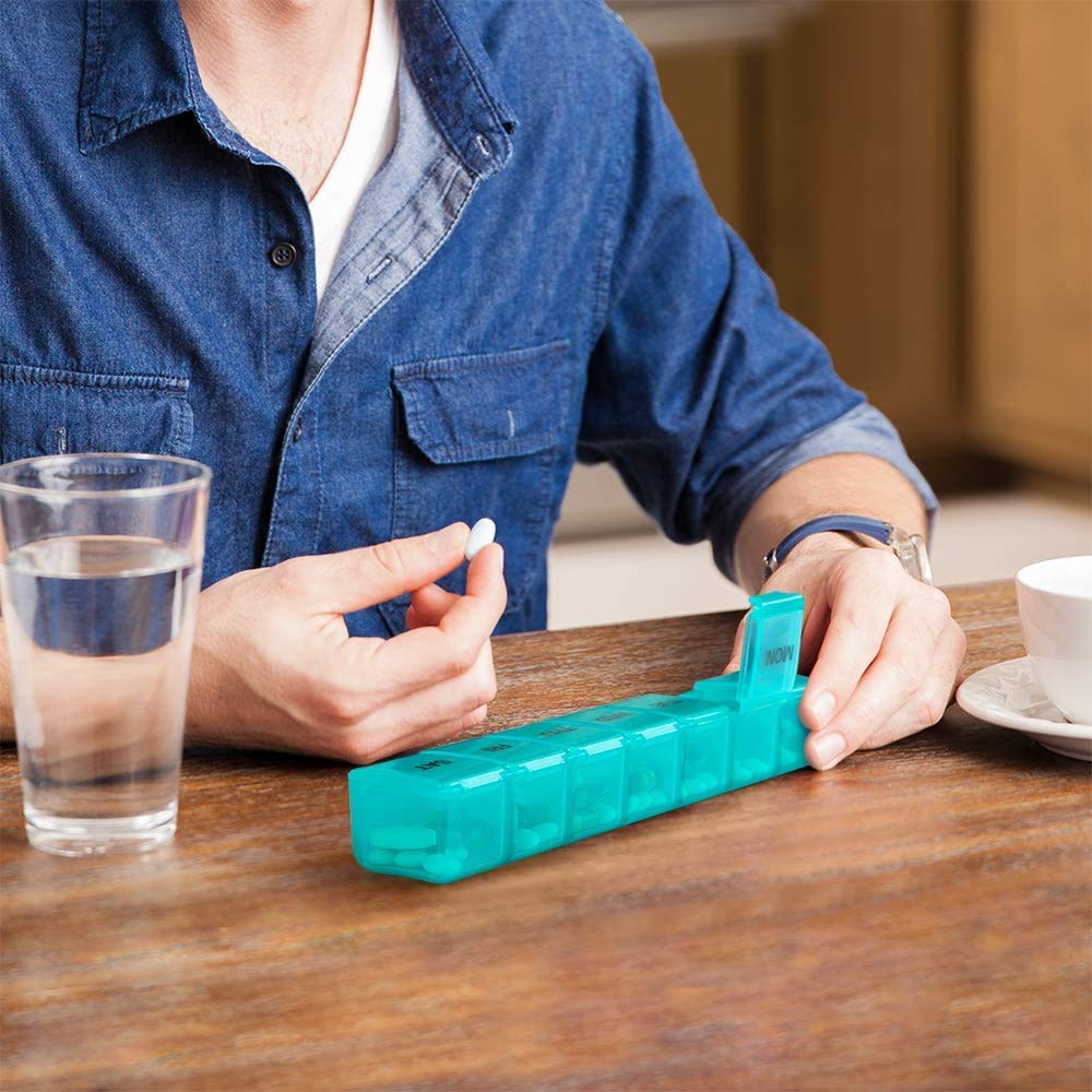 a person holding a pill in a container with text: 'MON'